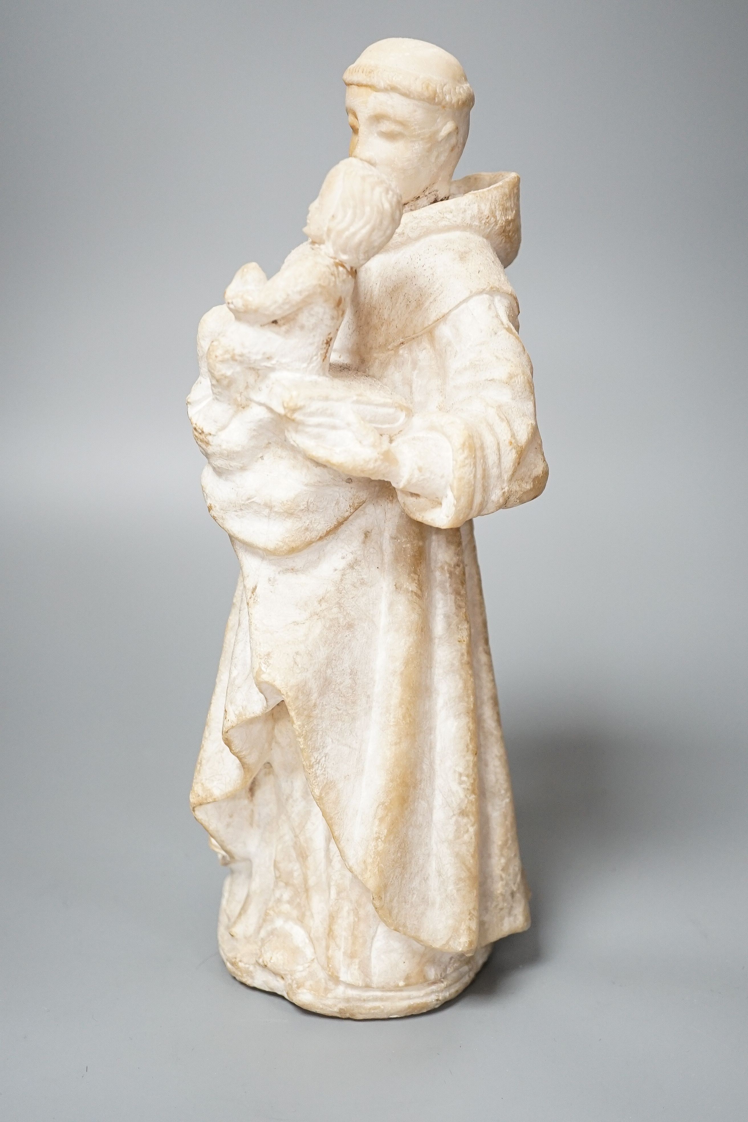 A 19th century carved alabaster group, friar with child 28cm